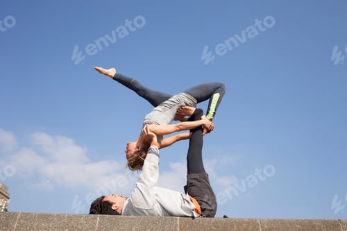 Vista previa: Man and woman on wall practicing acrobatic yoga