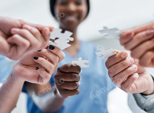Preview: Closeup shot of a group of medical practitioners holding puzzle pieces