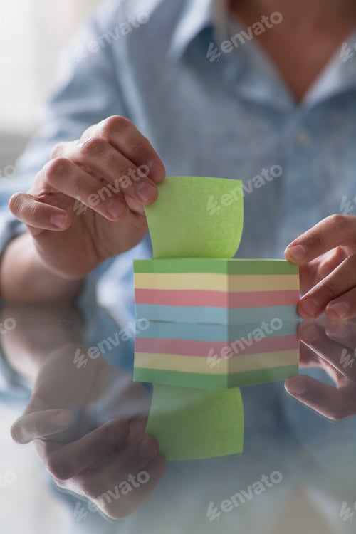 Preview: close up of a man picking up a post-it note