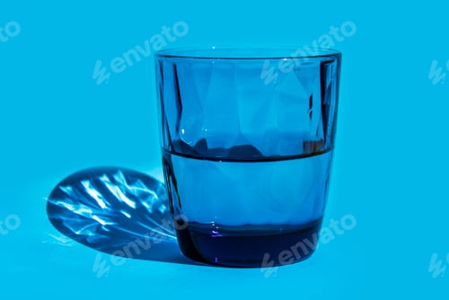 Preview: Pure Water in blue glass, on blue background. Glass of water for refreshment.