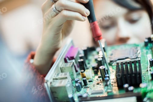 Preview: A woman using an electronic screwdriver on a computer circuitboard.