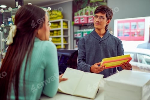 Preview: Salesperson showing air filter to customer in auto parts store