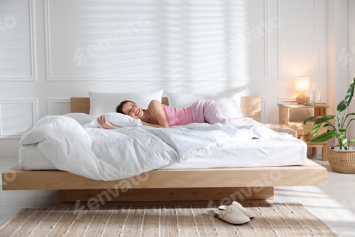 Preview: Woman lying on bed with soft mattress at home