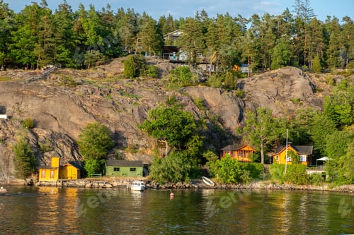 Preview: Stockholm Sweden Archipelago. Seafront villa, fishing hut, reflection in water, cloudy sky.