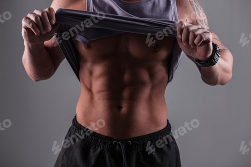 Preview: Muscular healthy athletic man with muscular body. Sports and health. Bodybuilder trainer