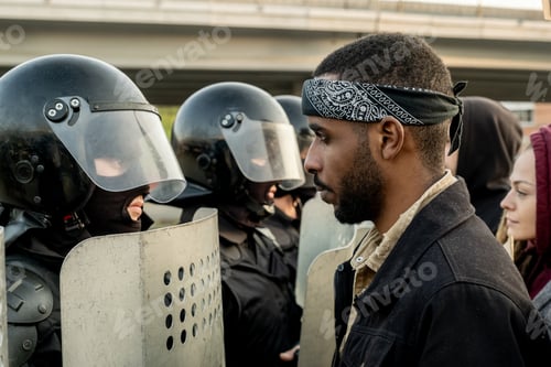 Preview: Black man standing in front of police officers
