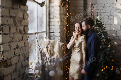 Preview: Affectionate Couple Embrace Beside a Christmas Tree