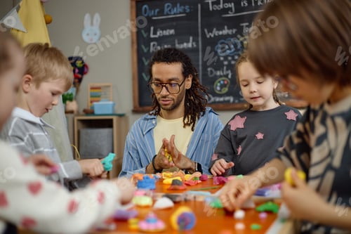 Preview: Multiethnic Kindergarten Children and Young Adult Man Creating Art Together