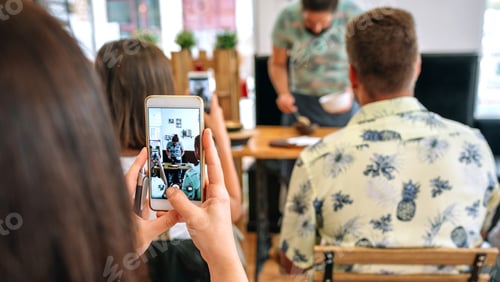 Preview: Woman taking photo with mobile in a cooking workshop