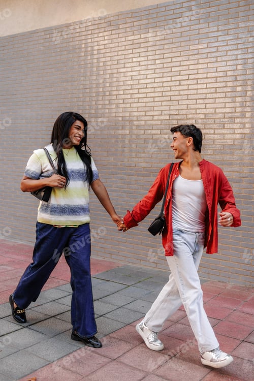 Preview: Happy latin couple holding hands and walking down the street