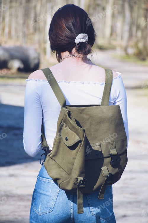 Preview: Young stylish teenage girl is wearing a khaki backpack. Student, high school, college