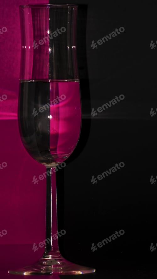 Preview: Vertical shot of a glass of water on a purple and black background