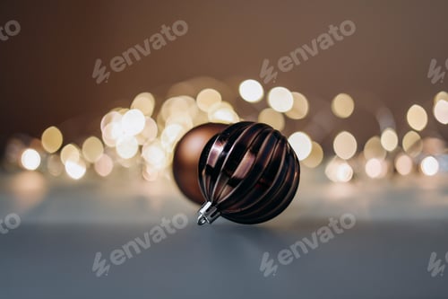 Preview: Christmas ball on brown background with bokeh lights