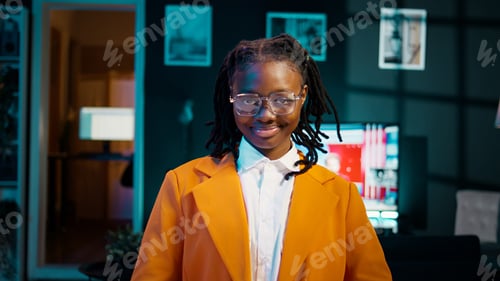Preview: Portrait of african american student putting glasses on and working