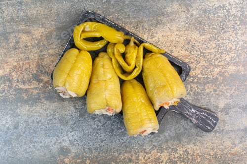 Preview: A dark board with salty peppers and cabbage on white background
