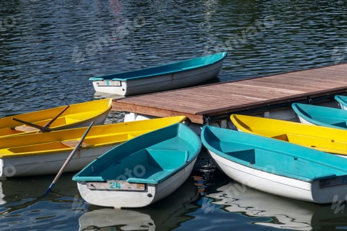 Preview: Colorful boats, yellow and blue, moored at a wooden dock on a body of water