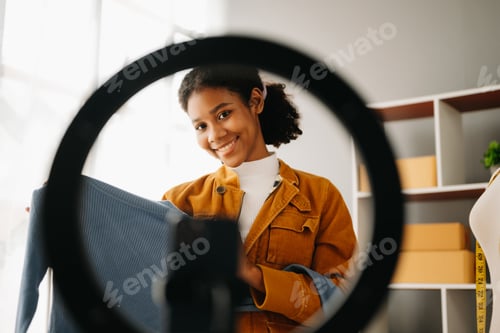Preview: Fashion blogger concept, Young African women selling clothes on video streaming.Startup small
