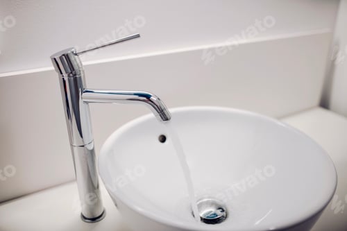 Water Flowing From a Faucet Into a Sink