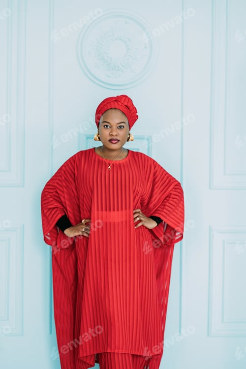 Preview: Front view of ethnic African lady wearing red stylish dress and headscarf, holding hands on her