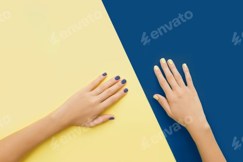 Preview: Hands with manicure on yellow and blue backgrounds.