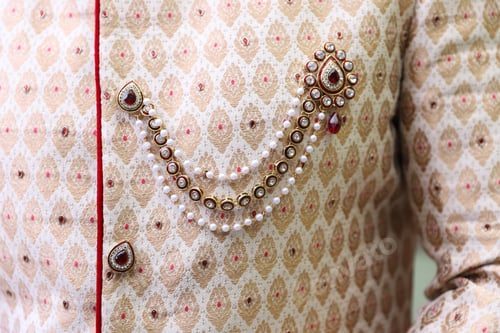 Preview: Close-up shot of the embraided sherwani worn by the groom in an Indian wedding ceremony