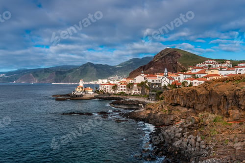 Preview: Marina da Quinta Grande, Madeira, Portugal. Seaside small village with lighthouse on rocky cliffs.