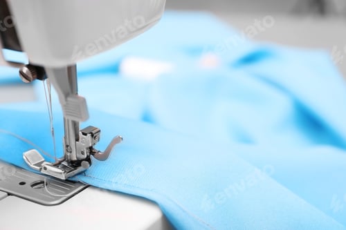 Preview: Sewing machine with fabric on table in tailor workshop, closeup