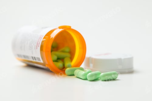Preview: Green capsules cascading out of orange bottle