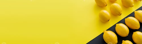Preview: Flat lay with organic lemons on yellow and black surface, banner