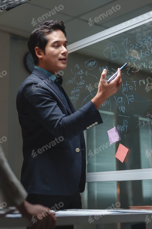 Preview: Businessman presenting new financial strategies on glass board