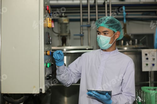 Preview: Factory worker examining a bottle in factory, technology industry business concept.