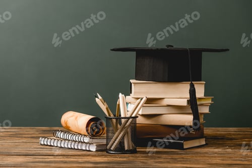 Preview: books, academic cap, notebooks, scroll, pencils on wooden surface isolated on grey
