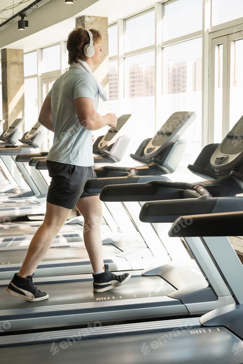 Preview: Athlete man running track, warming up on gym treadmill. Running at gym.