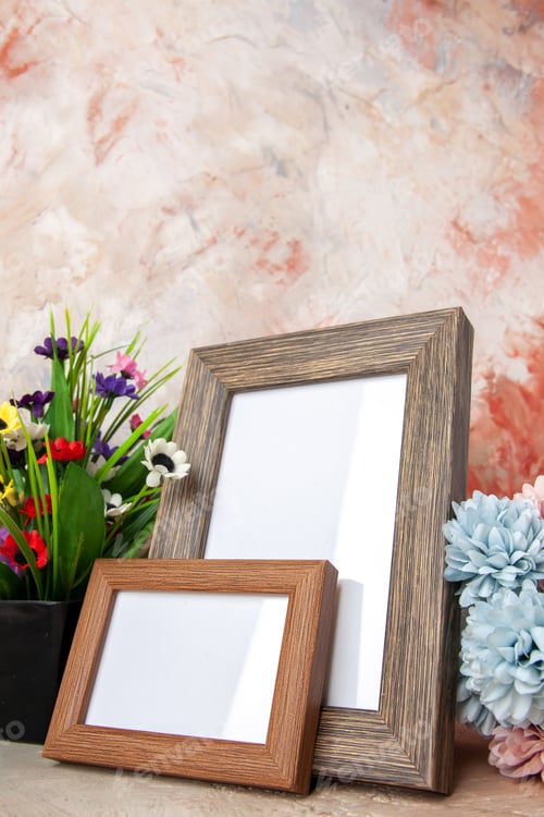 Preview: Front close view of dark brown empty wooden photo frames and beautiful flowers on mixed colors