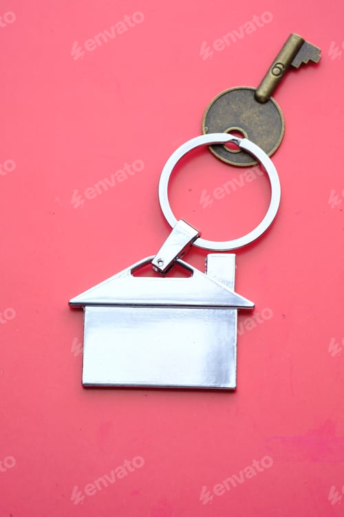 Preview: A Home Key with an Attractive HouseShaped Keychain set against a Beautiful Pink Background
