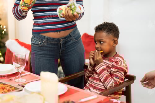 Visualização: Garoto africano feliz sentado à mesa de jantar no jantar de Natal