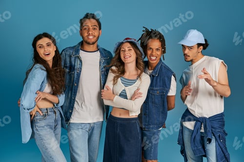 Preview: group portrait of multicultural friends in fashionable casual clothes looking at camera on blue