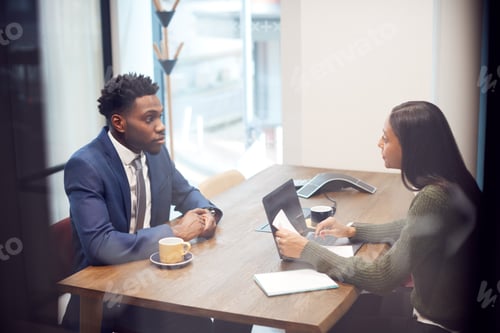 Preview: Businesswoman Interviewing Male Job Candidate In Meeting Room