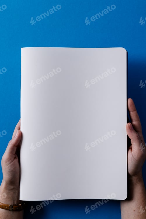 Preview: Hands of caucasian woman holding book with copy space on blue background