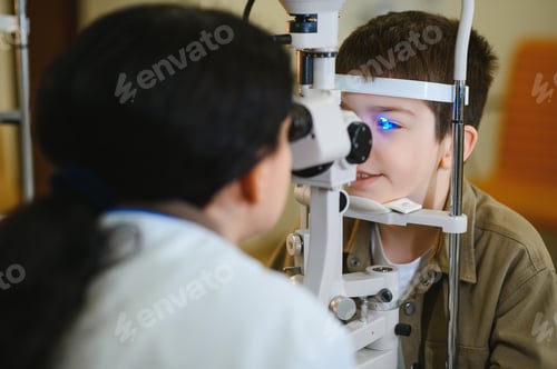 Preview: Ophthalmologist examining child's vision with modern equipment in clinic
