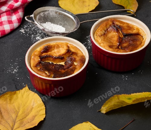 Preview: Cottage cheese dessert baked in portioned round ceramic plates on a wooden black table, top view