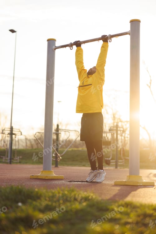 Preview: Man doing pull ups while working out outdoors