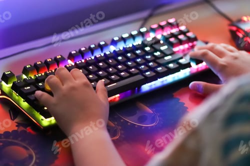 Preview: Gamer. A teenager is playing on the computer in the room.Keyboard computer,using technology