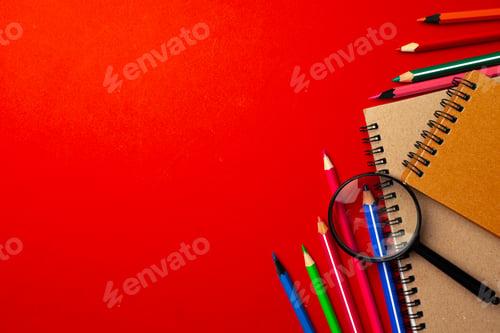 Preview: Colorful pencils and notepads on paper background top view