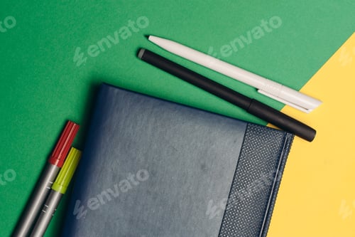 Preview: office supplies business finance notepad pens on yellow green background