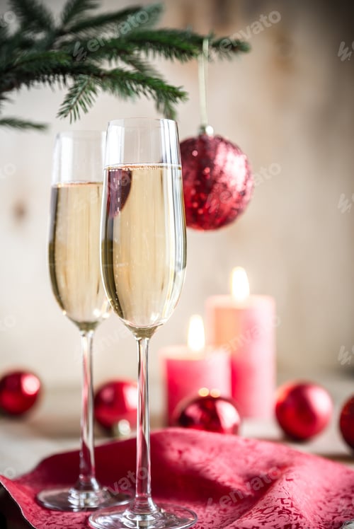 Preview: Glasses of champagne under decorated christmas tree branch