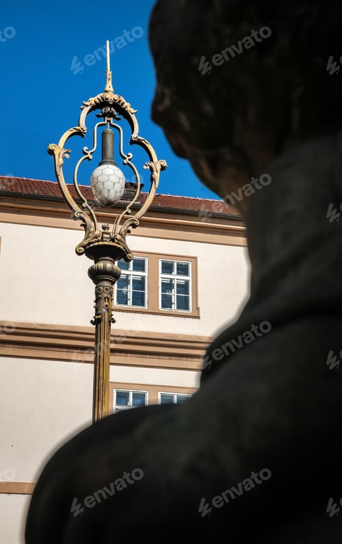Preview: street lamp through the silhouette of a sculpture in the city center of Prague
