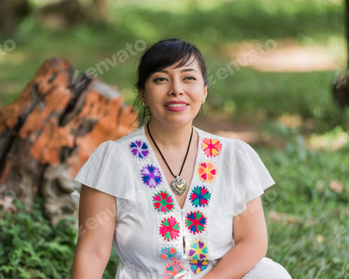 Preview: A woman wearing a white blouse adorned with colorful embroidered flowers.