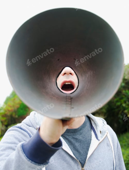 Preview: A man using a megaphone in the open air.