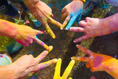 Preview: Friends putting their hands together in a sign of unity and teamwork. Holi colors festival